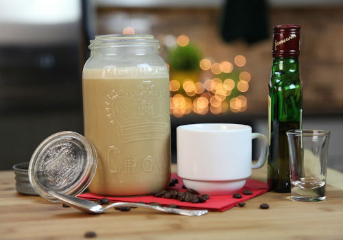 кофейный бейлиз в банке рядом с чашкой и бутылкой